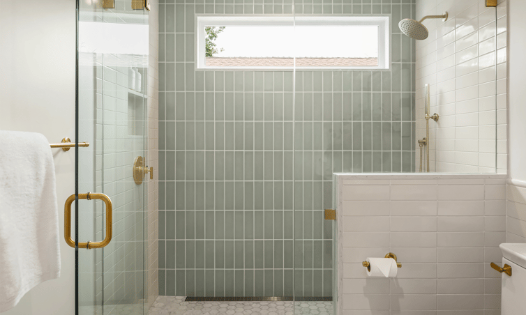 Spacious shower with glass doors and dusty teal tile
