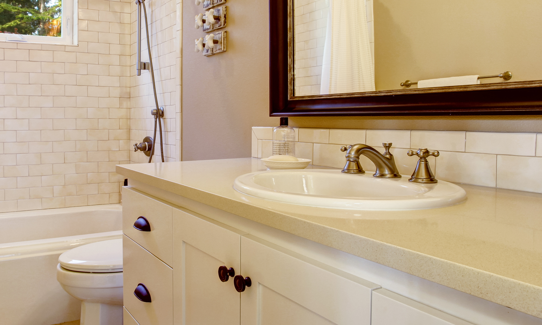 Drop in sink on white quartz countertop in traditional neutral bathroom